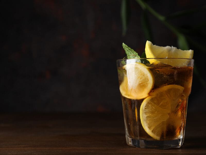 A glass of cold tea on a dark background